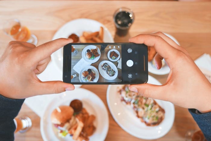 Phone above taking picture facing down of food on the table