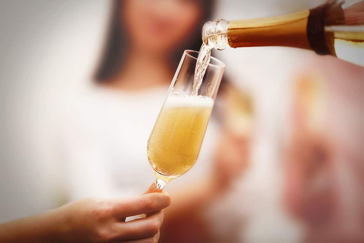 Pouring champagne into glass at a party for a tasting