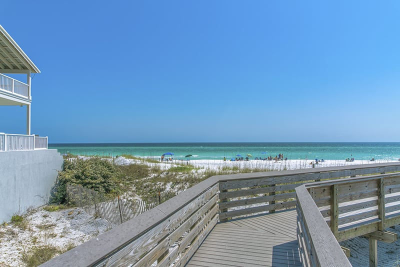 View of the beach with tourists on the shore from a boardwalk at Destin, Florida. 