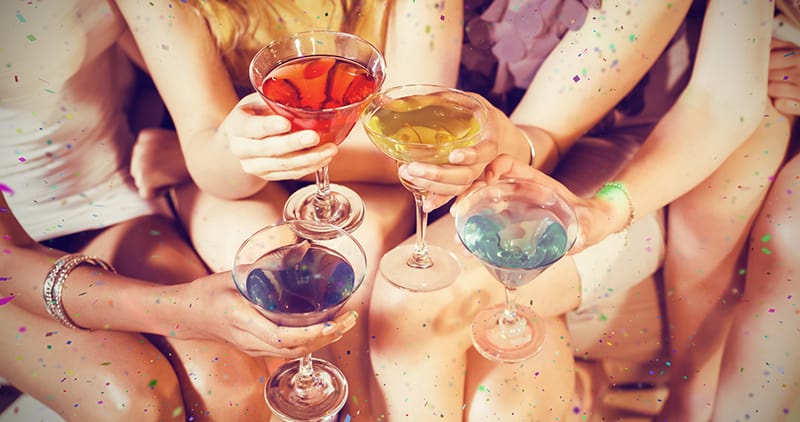Picture of women's hands holding martini glasses filled with cocktails