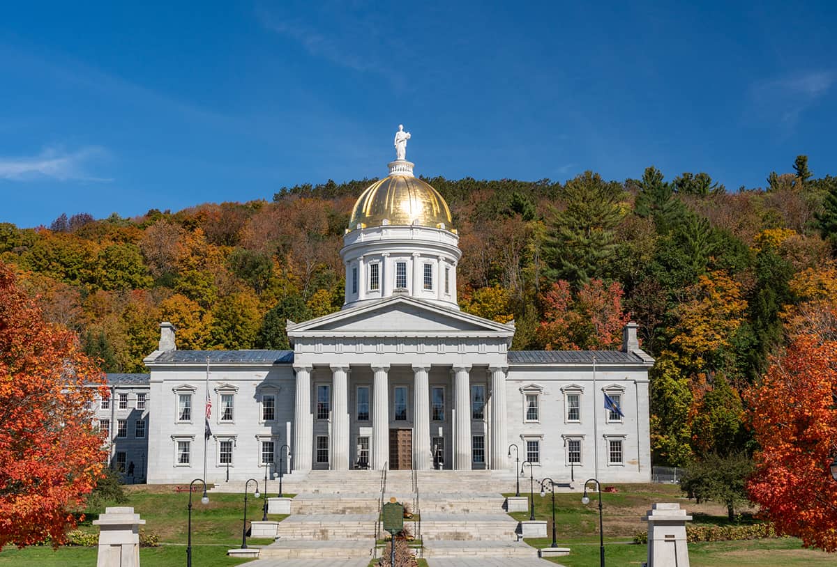 Gold leaf dome of the Vermont State House capitol building in Montpelier, Vermont. Brilliant fall colors surround the building