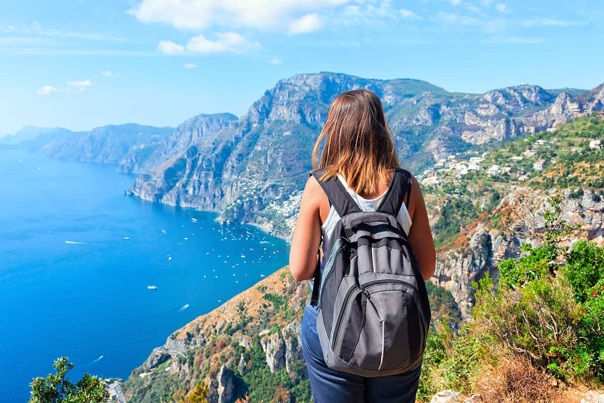 Woman backpacker at Path of Gods on Tyrrhenian sea, Amalfi coast, Italy