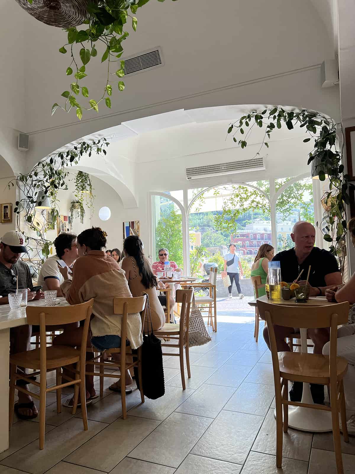 The inside of Casa e Bottega in Positano - plants hanging on the white walls looking out to the open street