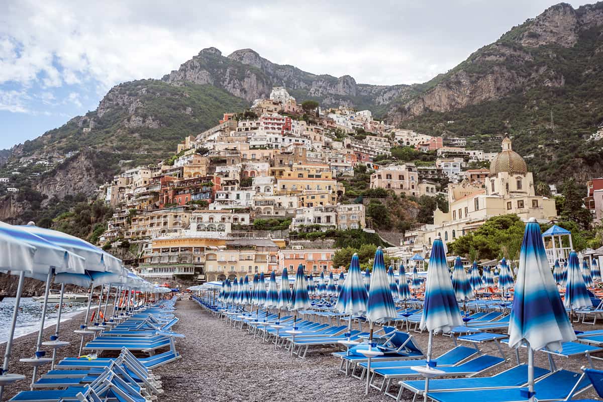 Positano beach with umbrella beds with Amalfi crags in the background - Spiaggia Grande the main beach